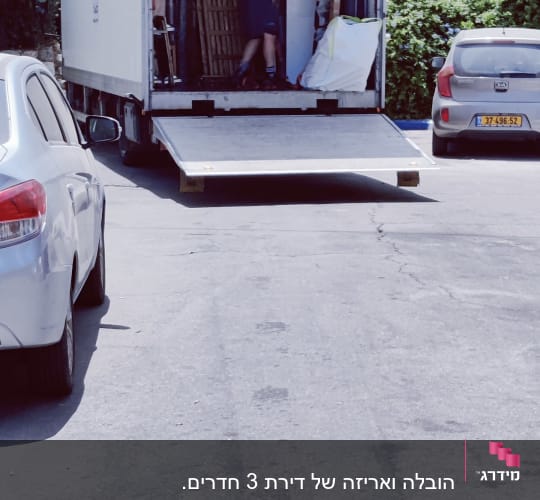 משאית הובלה פתוחה עם רמפה, אדם מעמיס חפצים